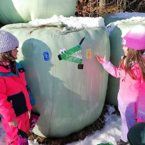 zwei Mädchen die überlegen, welche Uno-Spielkarten zum "größer als"-Zeichen passen