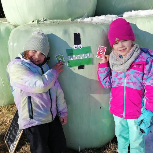 zwei Mädchen, die überlegen, welche Uno-Spielkarten zum Symbol "=" passen