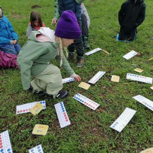 Kinder beim Zuordnen von großen Zahlen auf der Wiese